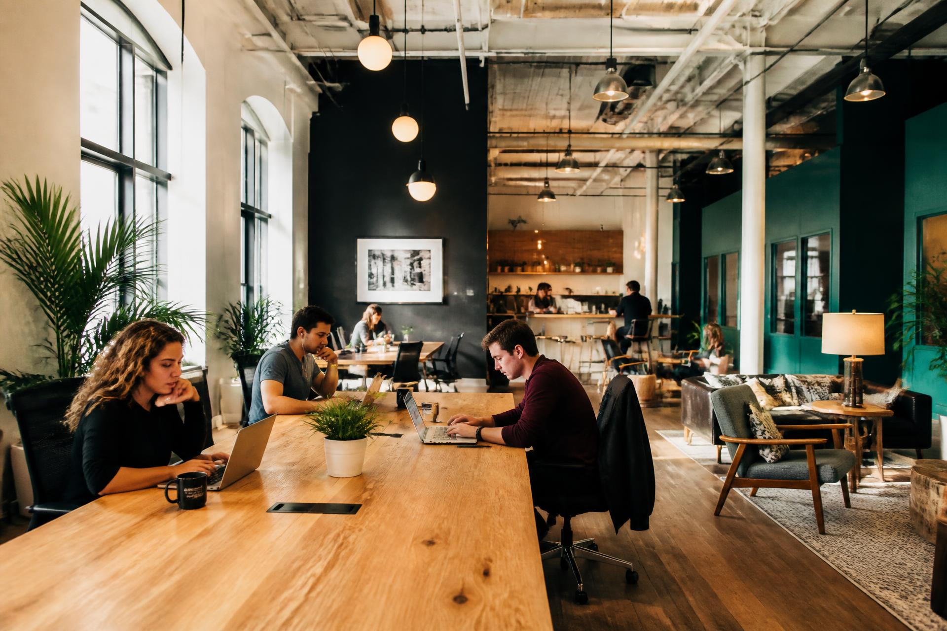 Svetao coworking radni prostor sa ljudima za zajedničkim stolom